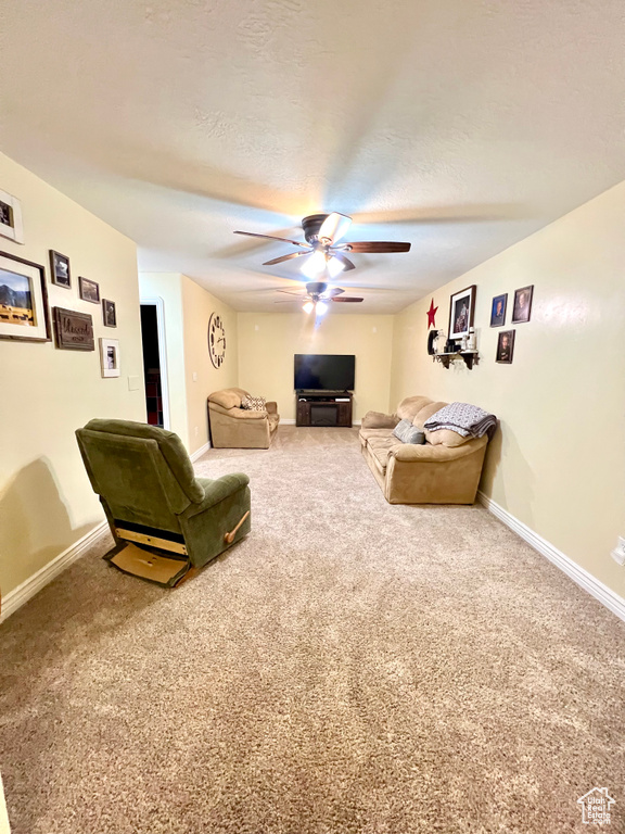 Living room featuring ceiling fan and carpet flooring