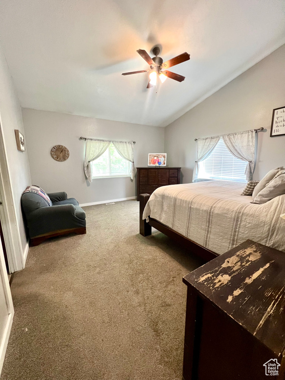 Carpeted bedroom with lofted ceiling and ceiling fan