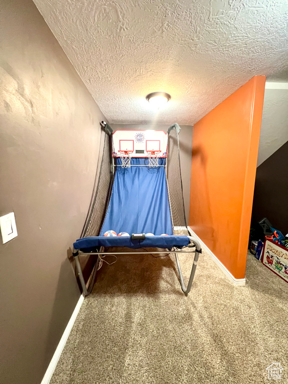 Playroom with carpet flooring and a textured ceiling