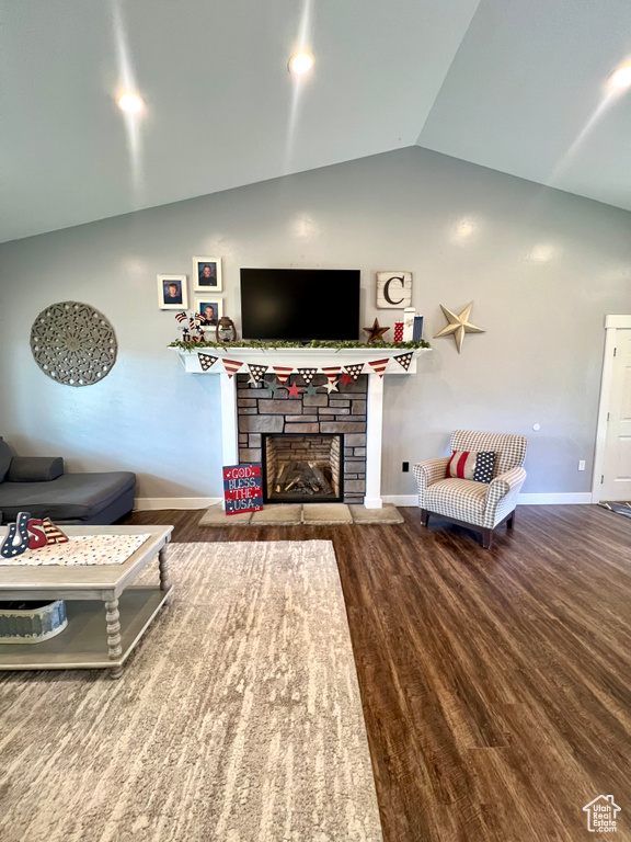 Living area with lofted ceiling, wood finished floors, and a fireplace