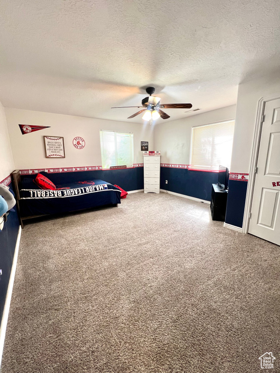 Bedroom featuring carpet flooring, a textured ceiling, and ceiling fan