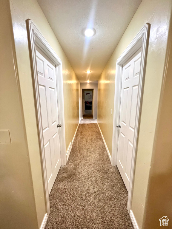 Hallway featuring carpet and baseboards
