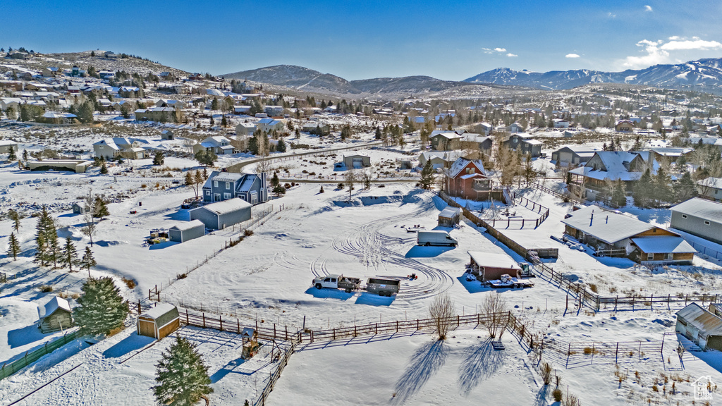 Snowy aerial view featuring a residential view and a mountain view
