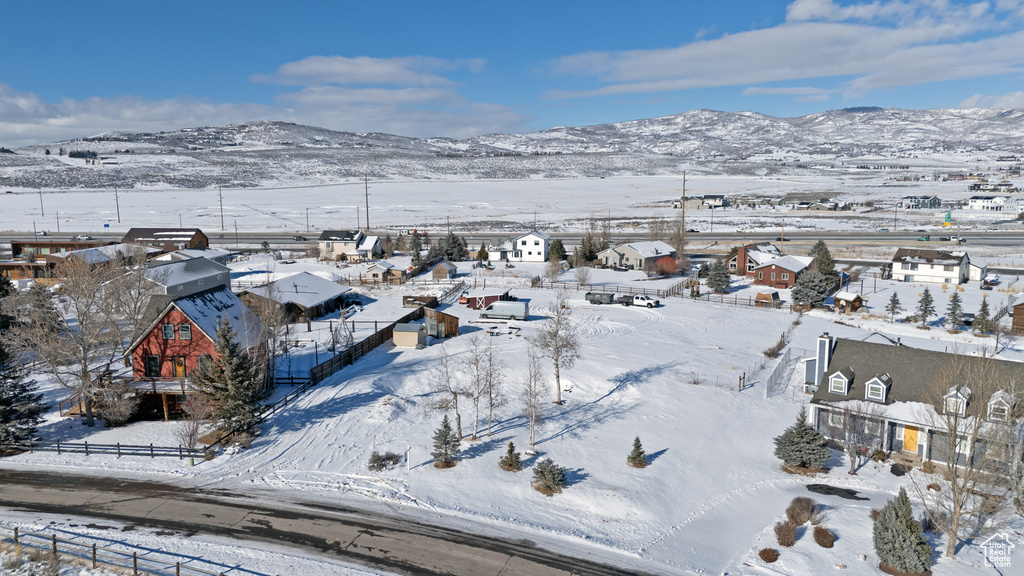 Snowy aerial view featuring a mountain view and a residential view