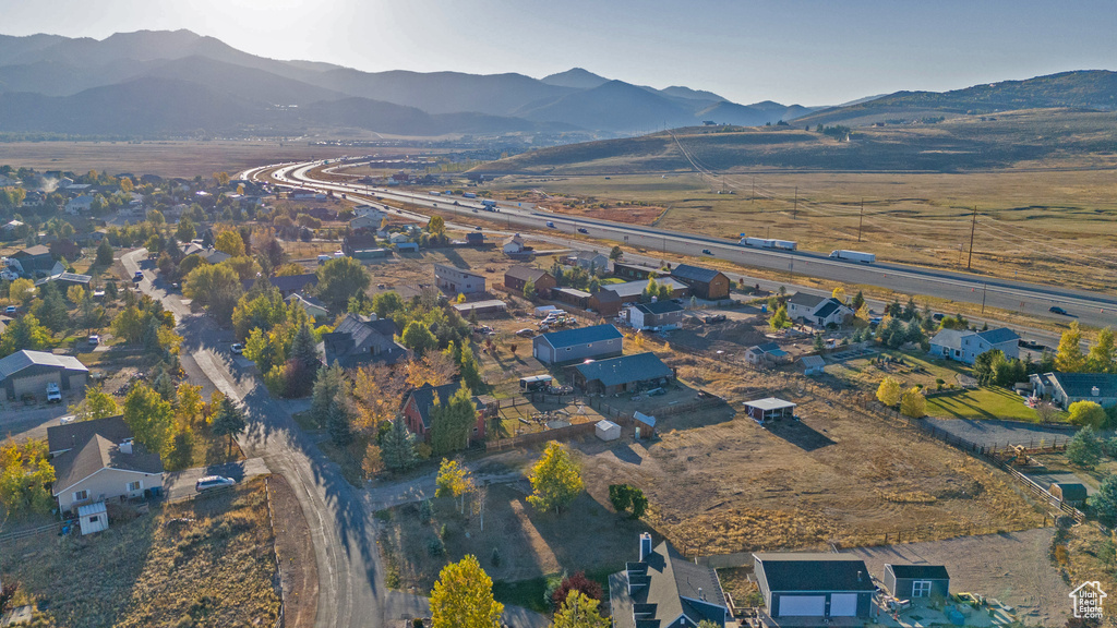 Aerial view of property and surrounding area featuring a mountainous background