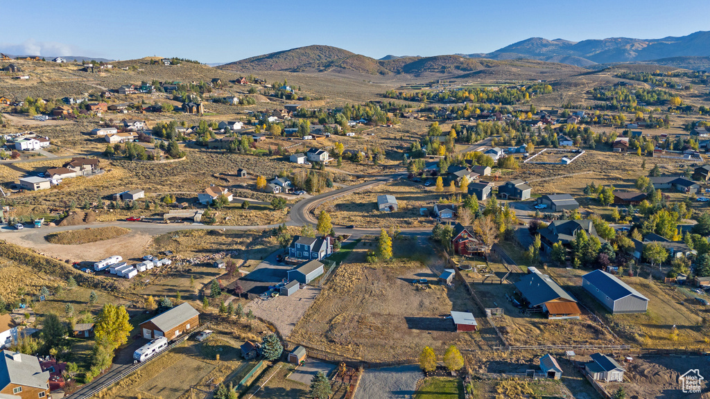 Aerial view of property's location featuring a mountainous background and nearby suburban area
