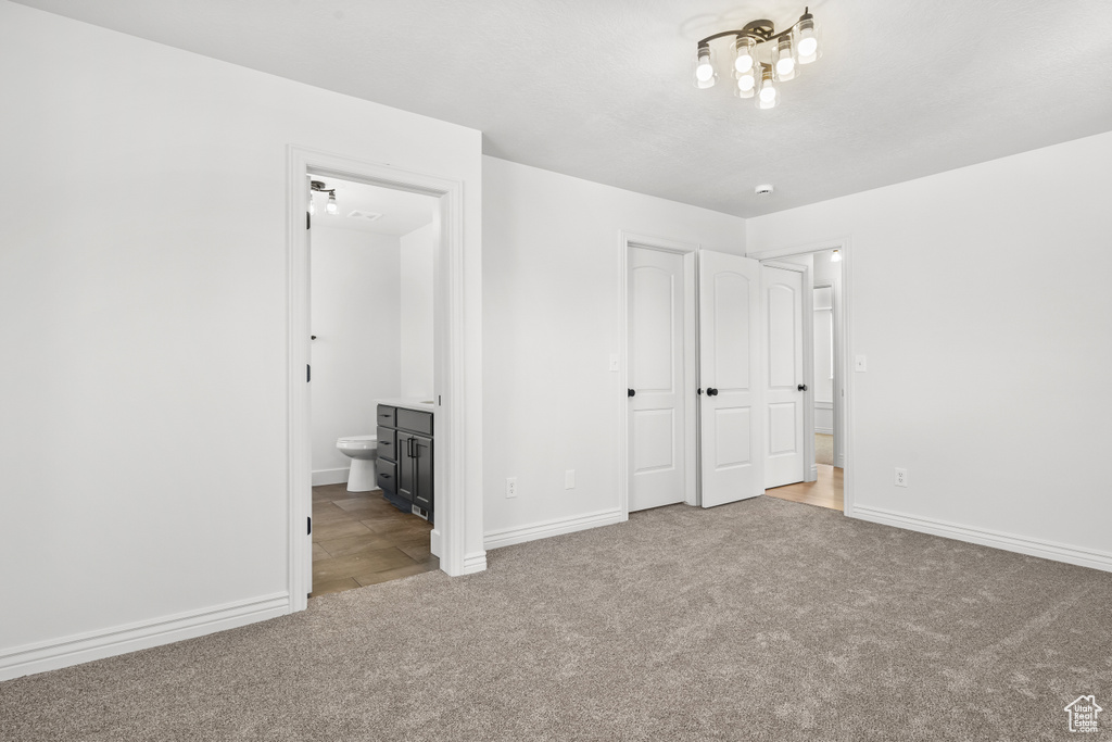 Unfurnished bedroom featuring carpet floors and ensuite bathroom