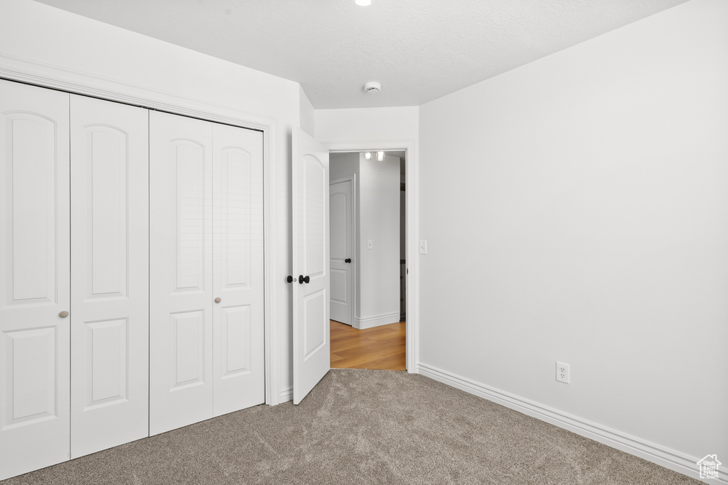 Unfurnished bedroom featuring a closet and carpet