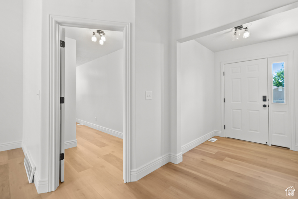Foyer entrance with light wood-type flooring and baseboards