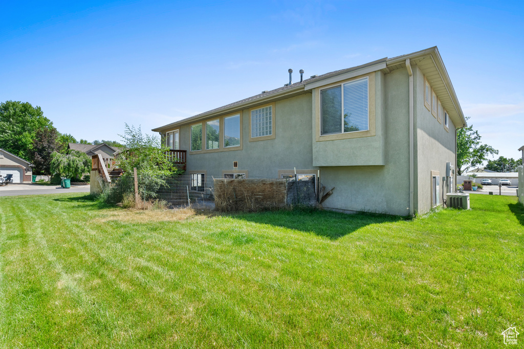 Back of house featuring stucco siding and a yard
