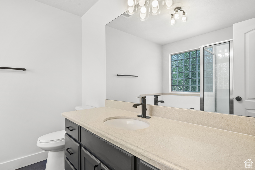 Bathroom with vanity, a shower stall, and a chandelier