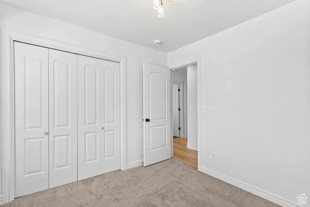 Unfurnished bedroom with carpet flooring and a closet