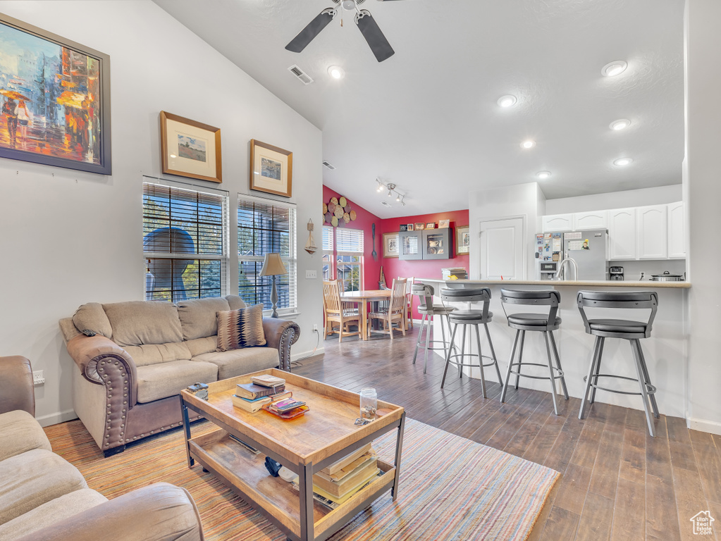 Living area featuring vaulted ceiling, ceiling fan, light wood-style floors, and recessed lighting