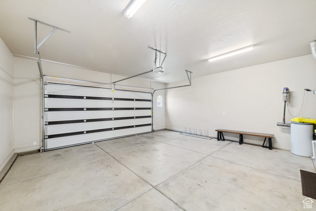 Garage featuring baseboards and a garage door opener