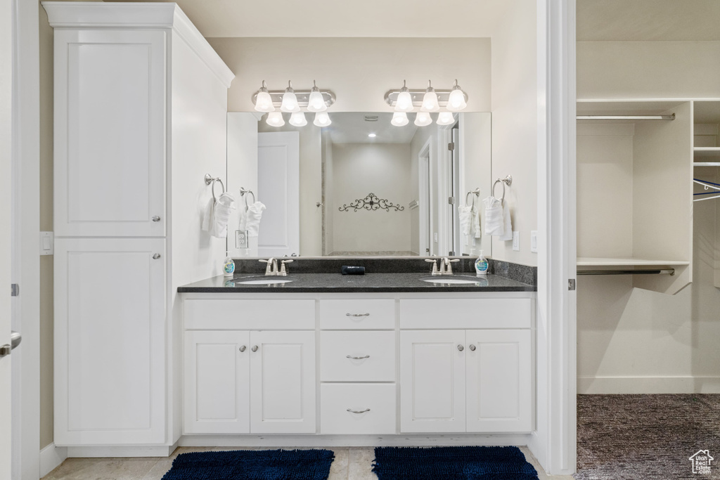 Full bathroom with double vanity and a walk in closet