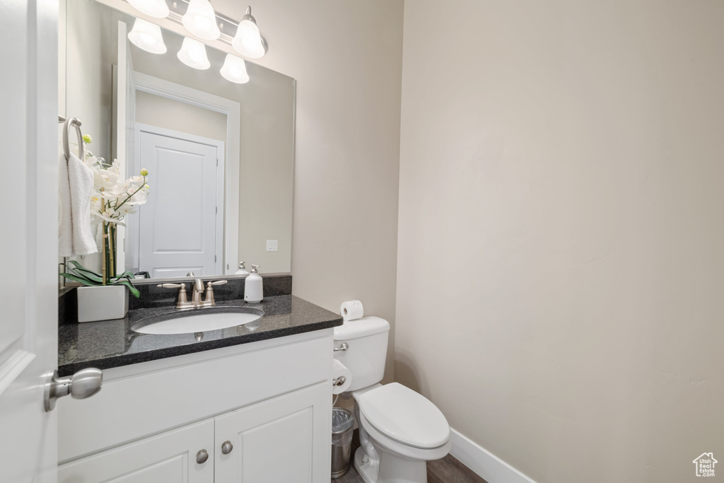 Half bathroom featuring vanity and toilet