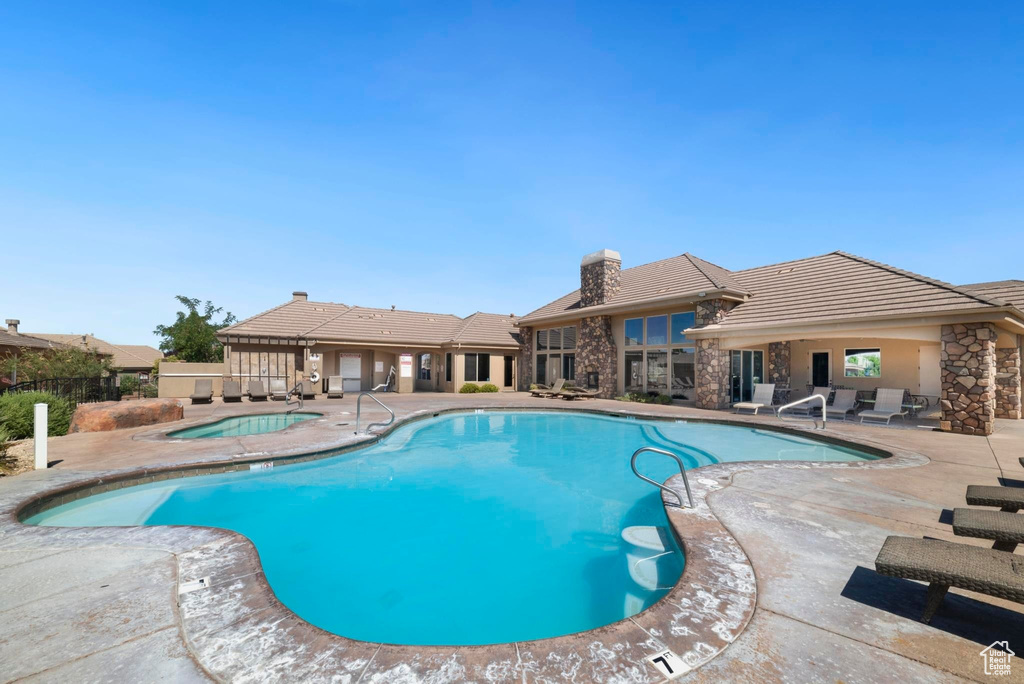 Community pool with a patio area and a hot tub