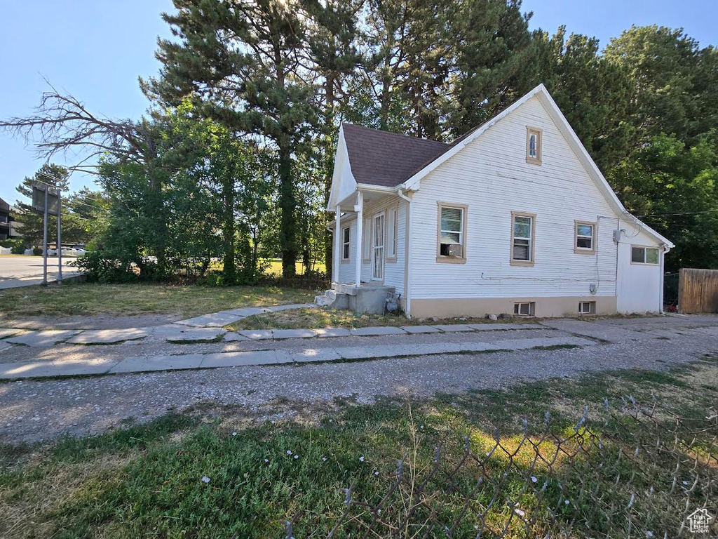 View of side of home featuring roof with shingles
