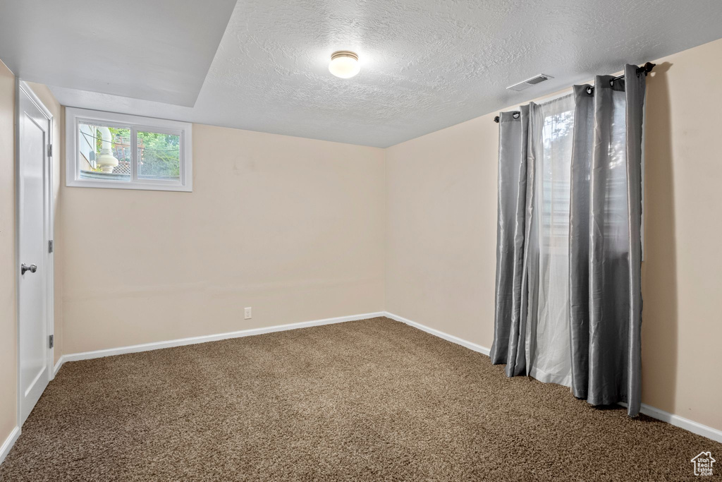 Spare room with carpet floors and a textured ceiling