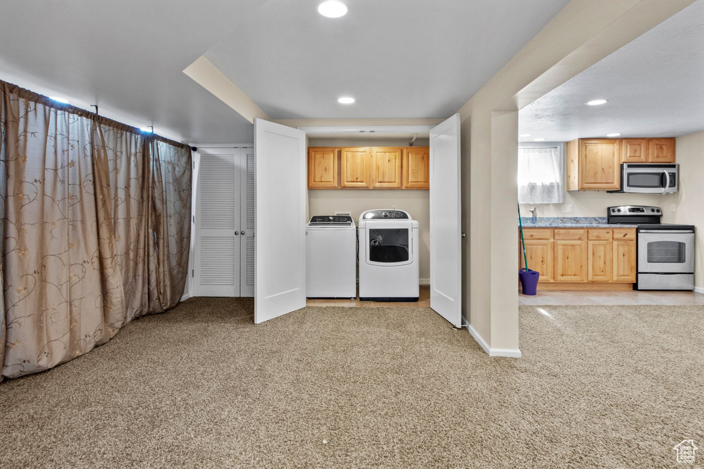 Kitchen with stainless steel appliances, washing machine and dryer, light carpet, recessed lighting, and light countertops