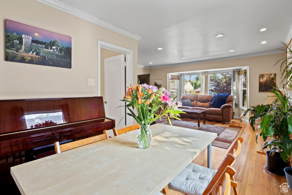 Dining area with crown molding, recessed lighting, and wood finished floors
