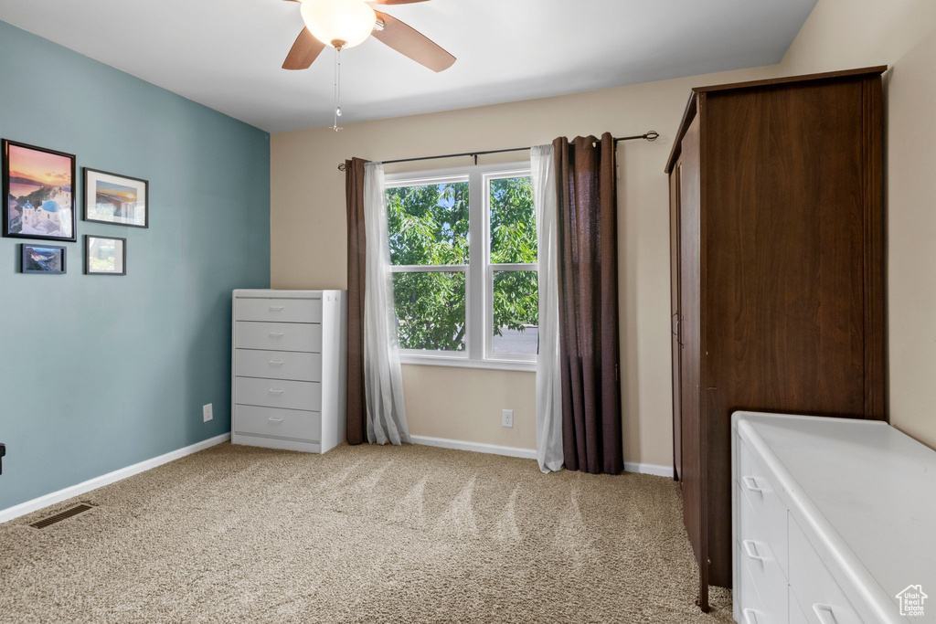Unfurnished bedroom featuring light colored carpet and a ceiling fan