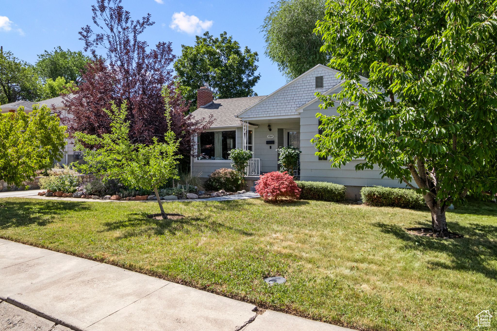 View of front of house featuring a front lawn and a chimney