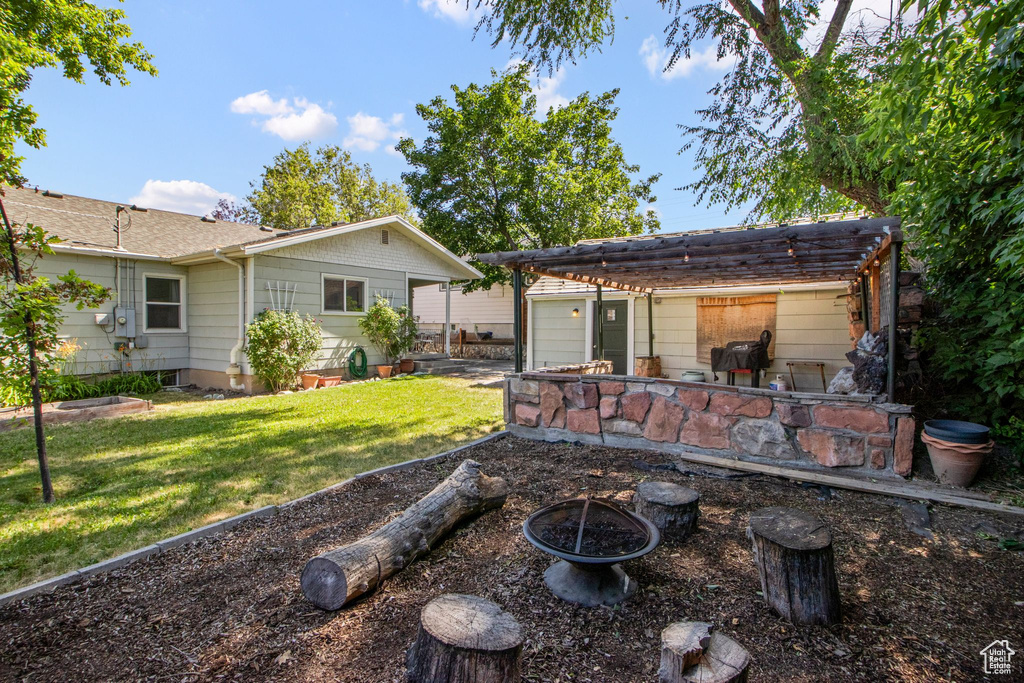 View of green lawn featuring an outdoor fire pit