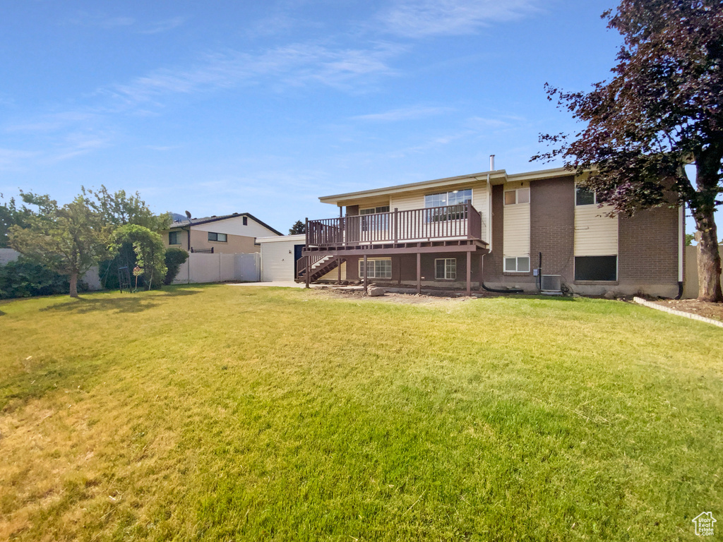 Rear view of property featuring a wooden deck, stairs, and brick siding