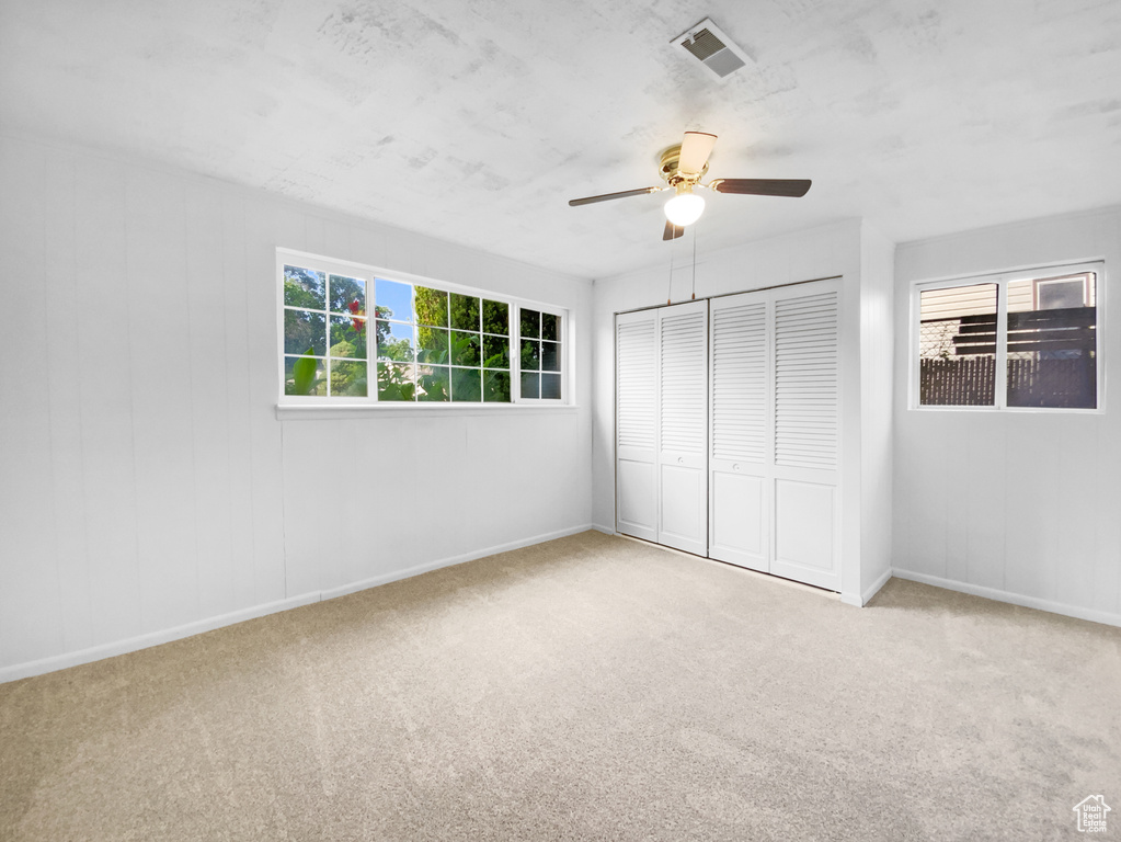 Unfurnished bedroom with carpet flooring, a closet, and ceiling fan