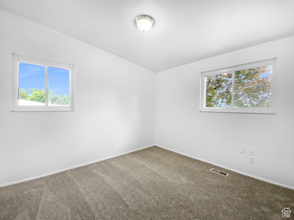 Carpeted empty room featuring baseboards