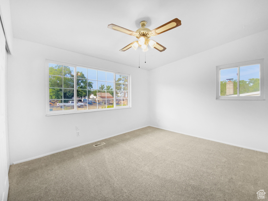 Spare room featuring carpet flooring and a ceiling fan