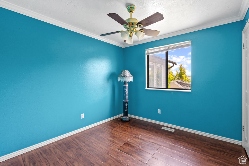 Spare room with ceiling fan, wood finished floors, ornamental molding, and a textured ceiling