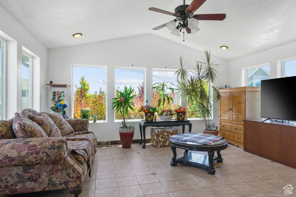 Living room with plenty of natural light, vaulted ceiling, ceiling fan, and light tile patterned floors