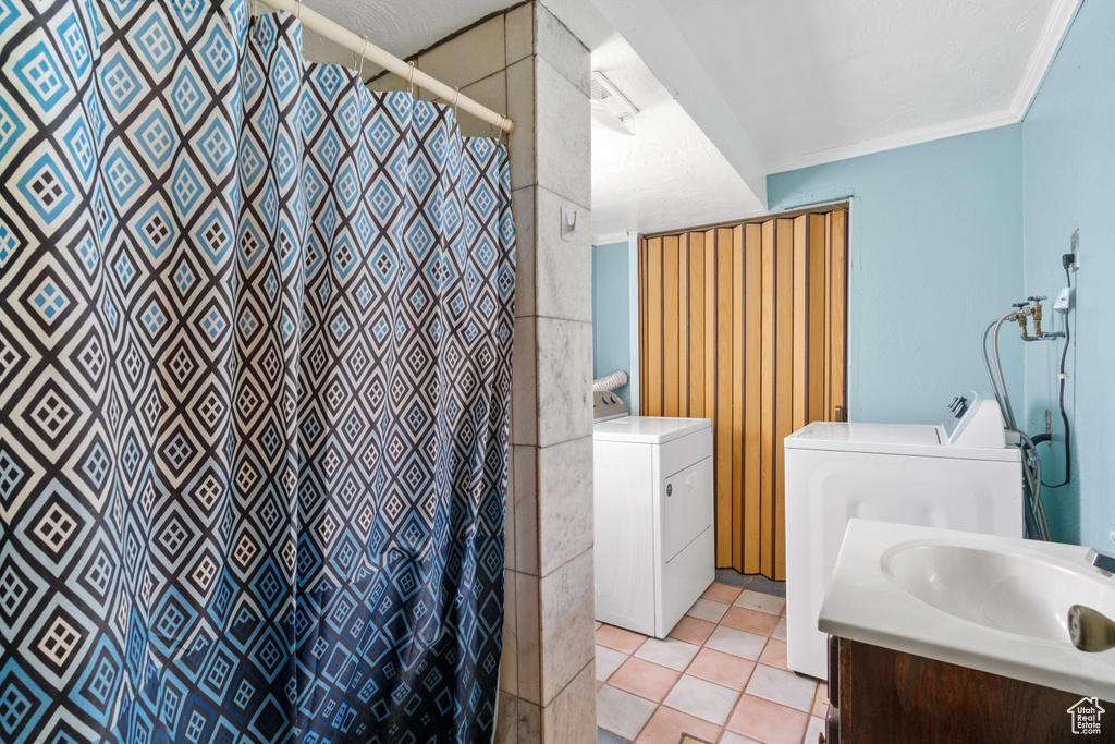 Bathroom featuring vanity, washing machine and dryer, a shower with shower curtain, and tile patterned floors