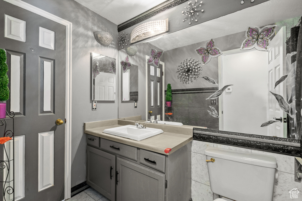 Half bathroom featuring vanity and tile patterned flooring