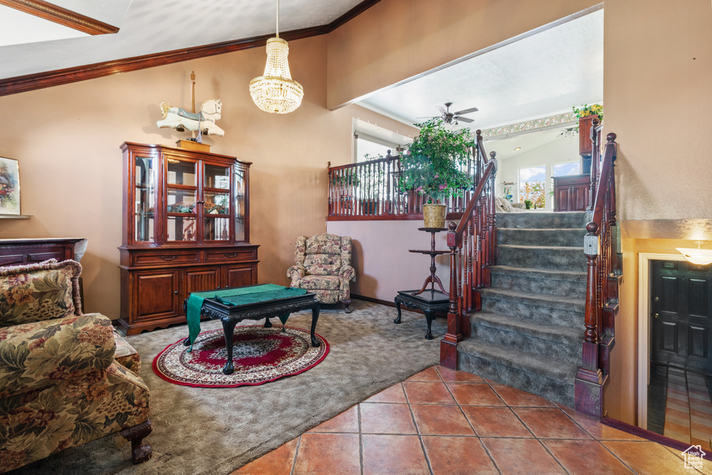 Living area featuring crown molding, stairs, plenty of natural light, tile patterned floors, and a chandelier