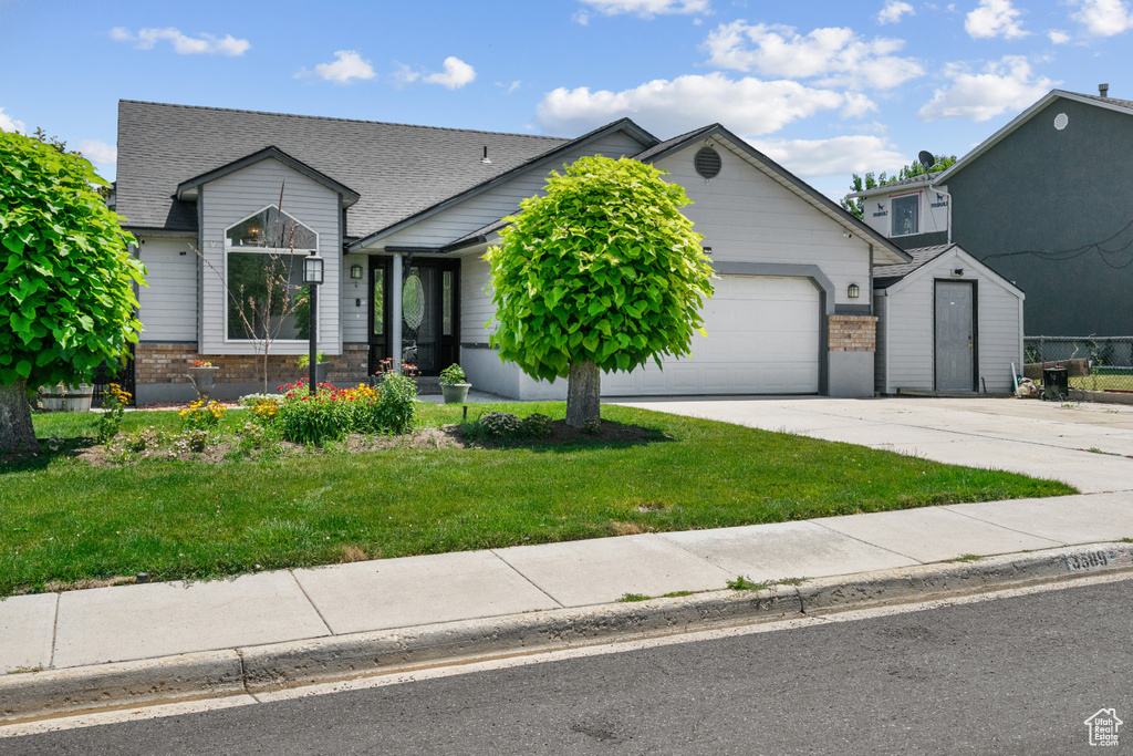 Ranch-style house with an attached garage, driveway, a front lawn, brick siding, and roof with shingles