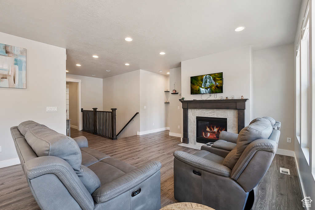 Living room featuring recessed lighting, wood finished floors, and a fireplace