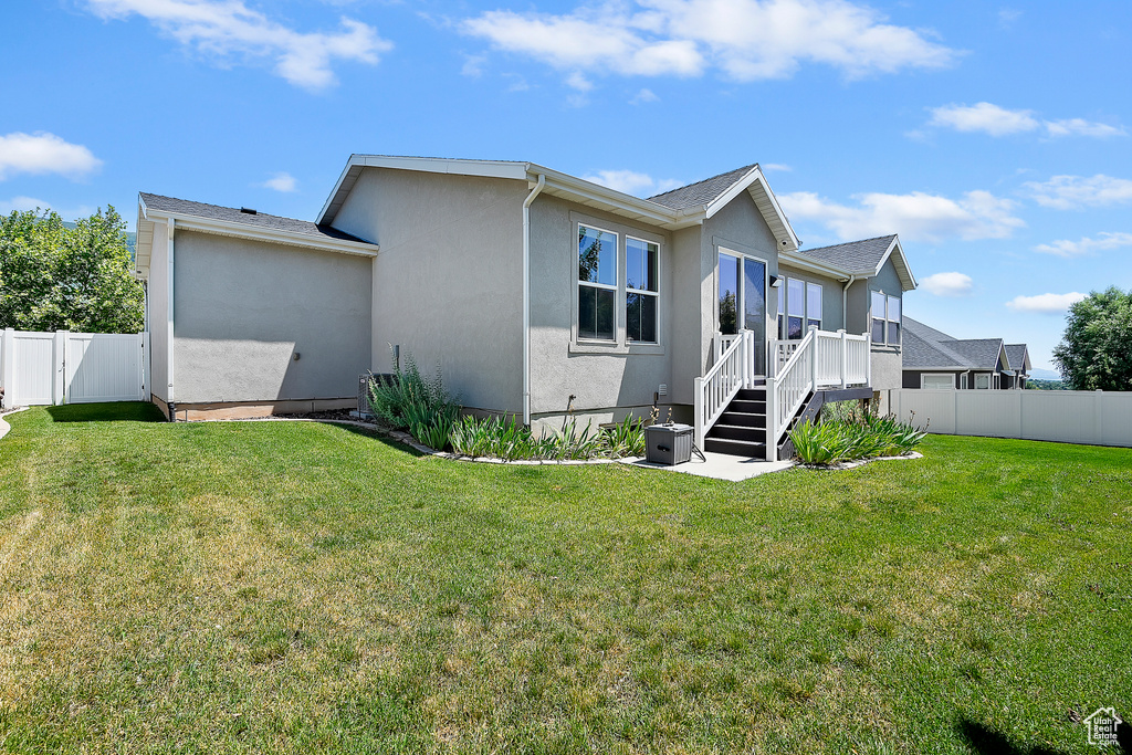 Back of house with stucco siding and a fenced backyard
