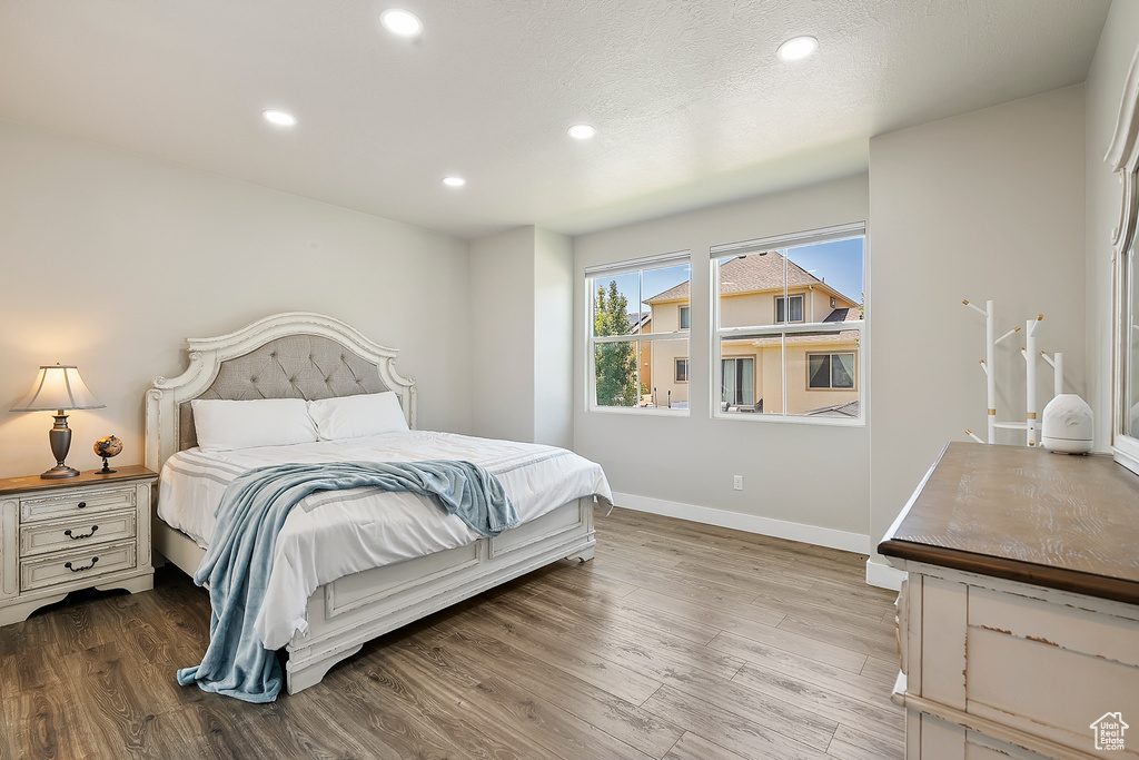 Bedroom with wood finished floors and recessed lighting