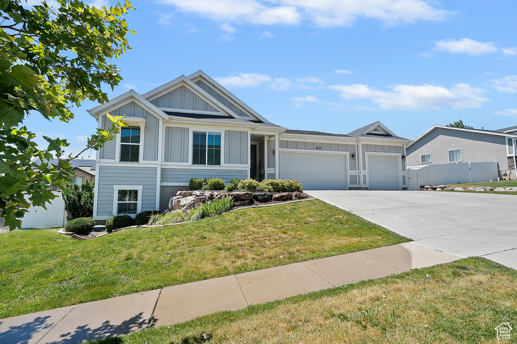 View of front facade featuring board and batten siding, concrete driveway, and an attached garage