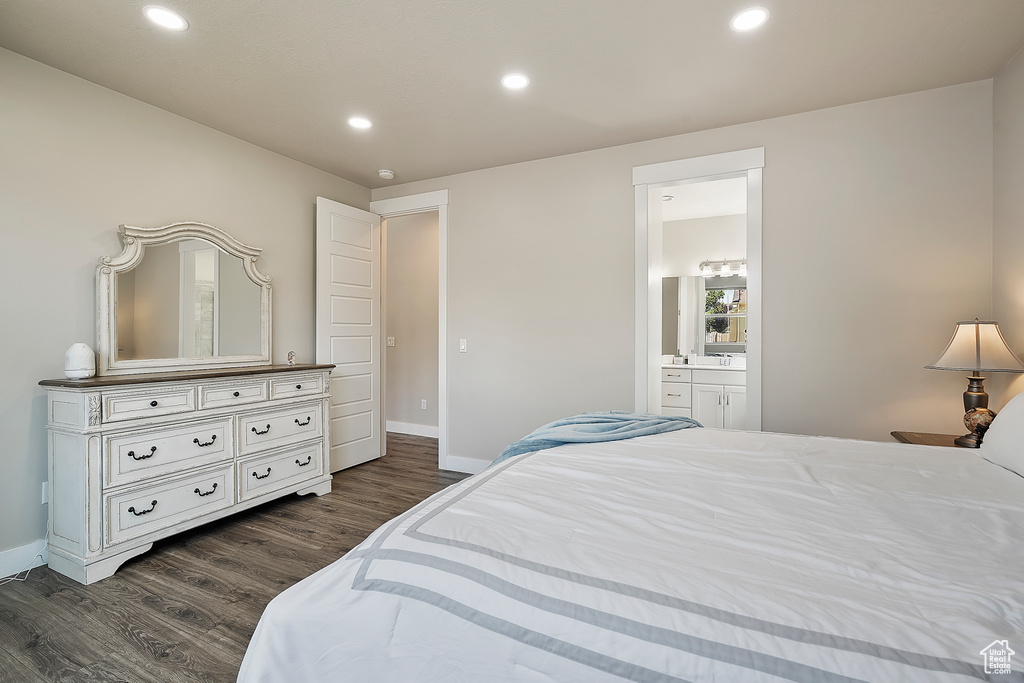 Bedroom with dark wood-style floors, recessed lighting, and ensuite bath