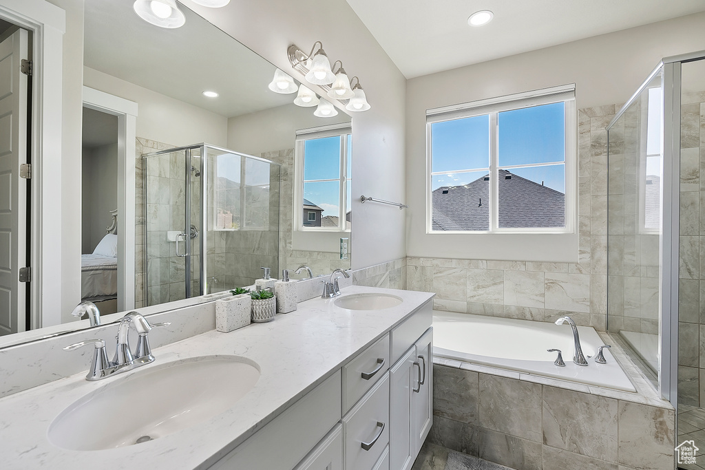 Full bath featuring a bath, a shower stall, double vanity, connected bathroom, and recessed lighting