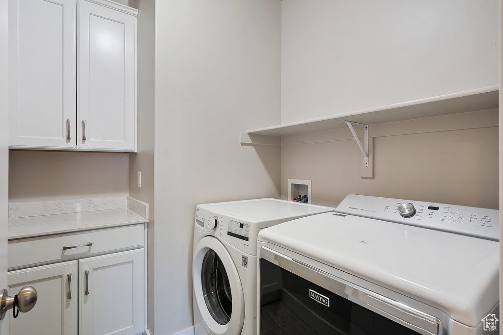 Washroom featuring washing machine and clothes dryer and cabinet space