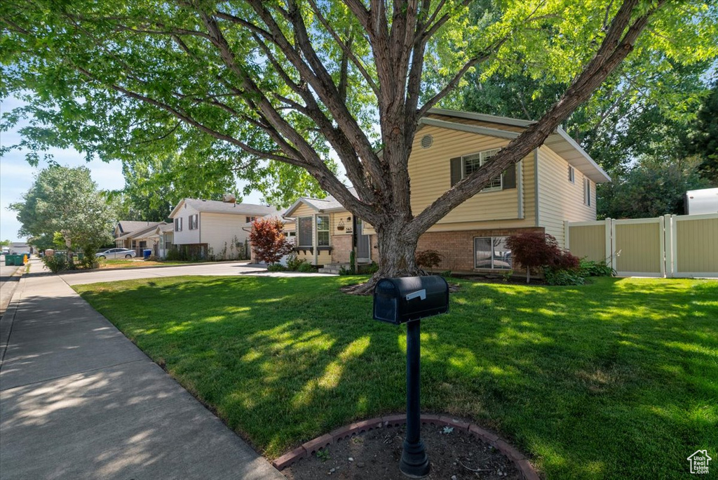 View of front of property featuring driveway, brick siding, and a gate