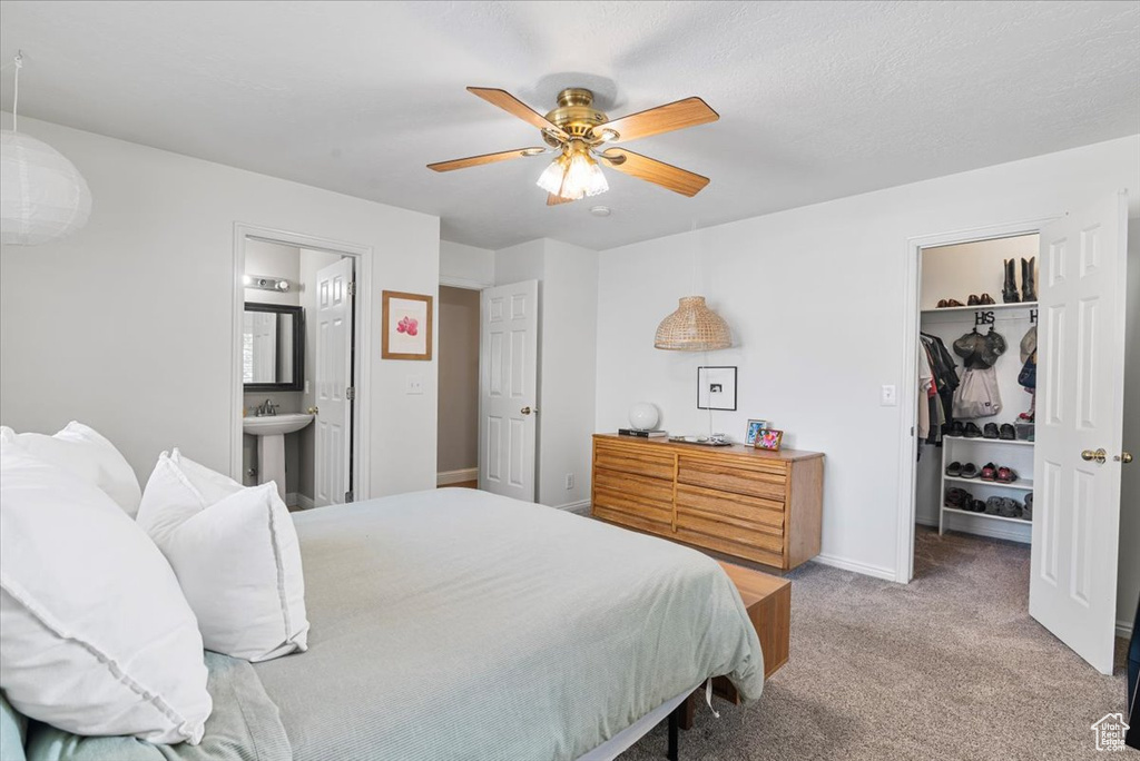 Bedroom featuring a spacious closet, carpet flooring, ensuite bathroom, a closet, and ceiling fan