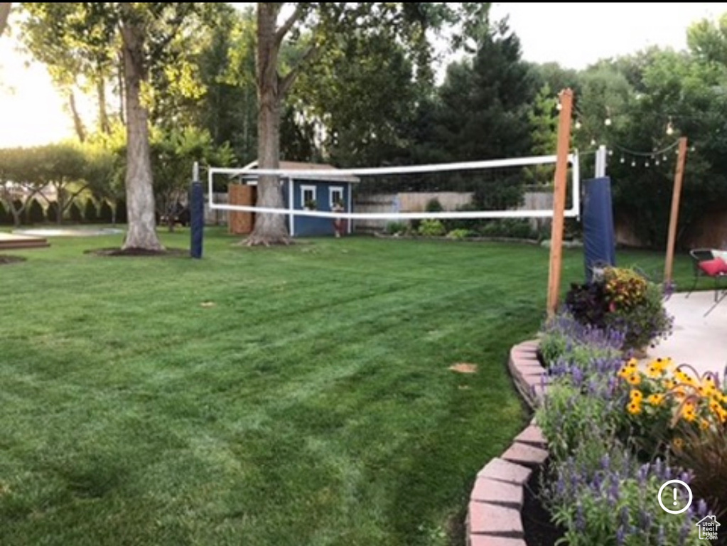 View of property\\\'s community featuring volleyball court and a lawn