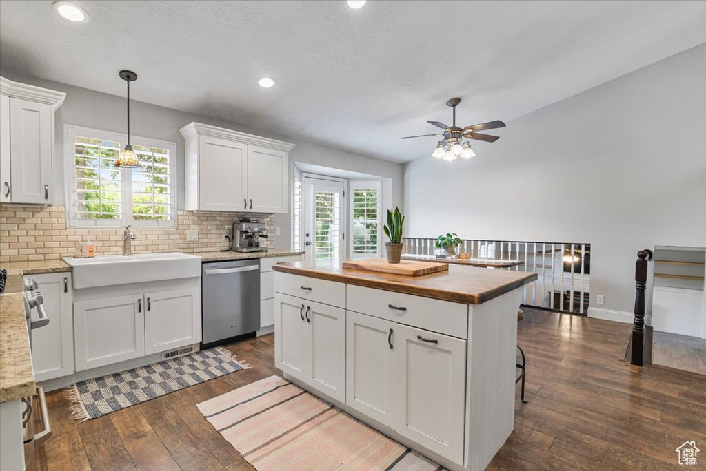 Kitchen featuring dishwasher, butcher block countertops, dark wood-type flooring, tasteful backsplash, and a ceiling fan