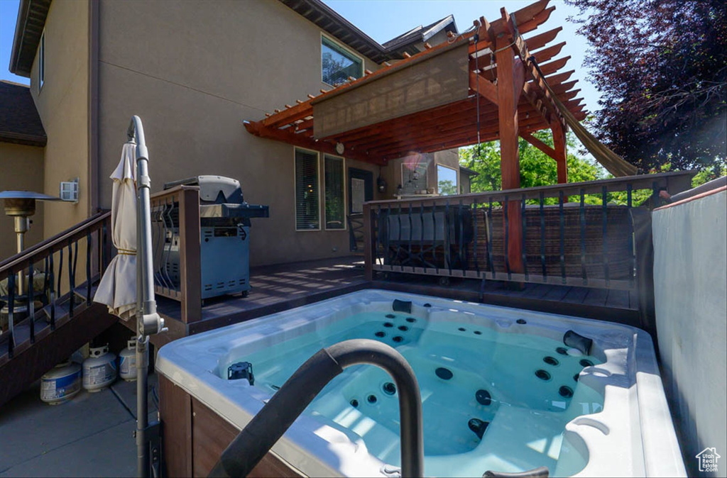 View of swimming pool featuring a wooden deck, a hot tub, a grill, and stairs